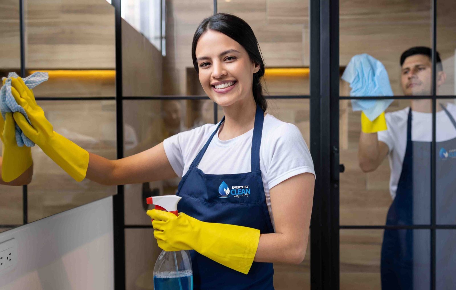 Happy professional cleaners cleaning a bathroom at an apartment